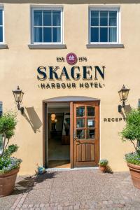 un bâtiment avec un panneau indiquant skeagen harcourt hotel dans l'établissement Skagen Harbour Hotel, à Skagen
