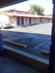 an empty parking lot with two barriers in front of a building at Deluxe Inn Austin in Austin