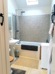 uma casa de banho com uma banheira e um lavatório em Wayside House B&B em Whichford