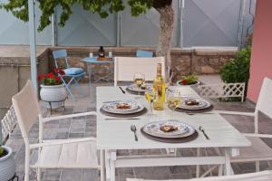 uma mesa branca com pratos e taças de vinho em Sea Dream em Sami