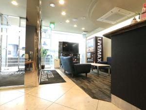 a lobby with a waiting room with a chair and a table at HOTEL LiVEMAX BUDGET Shinbashi in Tokyo