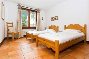 1 dormitorio con 2 camas, silla y ventana en APARTMENT KITSON - Alpes Travel - Chamonix - Sleeps 6 en Chamonix-Mont-Blanc