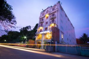 a tall white building with lights on a street at Hotel Shwe Yee in Yangon