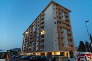 un edificio alto con coches estacionados en un estacionamiento en Apartments Doclea en Podgorica