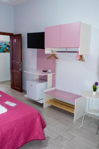 a bedroom with pink and white cabinets and a table at B&B Le isole in Naples