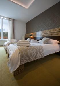 ein Hotelzimmer mit 3 Betten und weißer Bettwäsche in der Unterkunft Gold Club Hotel & Casino in Ajdovščina