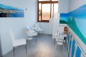 ナポリにあるB&B Le isoleのテーブル2台と椅子、窓が備わる客室です。