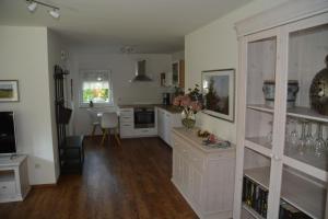 a kitchen with white cabinets and a dining room at Im Maifeld in Kalt