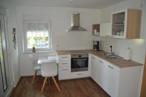 a kitchen with white appliances and a table and chairs at Im Maifeld in Kalt