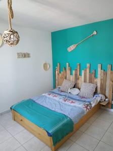 a bed with a wooden headboard in a room at Résidence Village Marin Catalan TORREILLES PLAGE in Torreilles