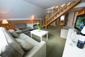 a living room with a couch and a table with a tv at Warmia Park in Olsztyn