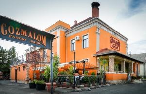 pomarańczowy budynek z napisem przed nim w obiekcie Gőzmalom Étterem és Panzió w mieście Körmend