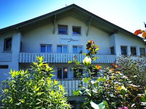 a white building with a sign on the side of it at Pension Mozart in Ottobeuren