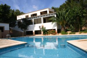 a villa with a swimming pool in front of a house at Viviendas Turísticas Vacacionales Allida in Playa Migjorn