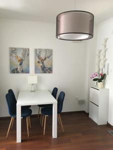 a dining room with a white table and chairs at Petőfi Vendégház in Kiskőrös