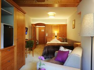 ein Hotelzimmer mit einem Bett und einem Sofa in der Unterkunft Klammers Kärnten in Bad Hofgastein