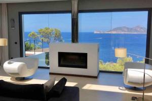 sala de estar con chimenea y vistas al océano en ALMA Luxury Villa with sunset, en Andratx