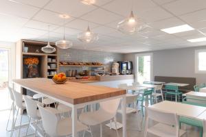 cocina y comedor con mesa y sillas en Kyriad Montpellier Ouest St Jean de Védas - A709, en Saint-Jean-de-Védas