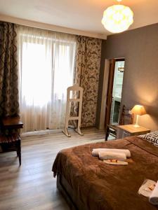 a hotel room with a bed and a large window at Apartment Jorjo Mestia in Mestia