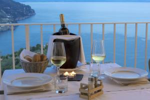 un tavolo con una bottiglia di vino e due bicchieri di Villa Piedimonte a Ravello