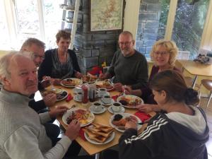 a group of people sitting around a table eating food at Plas Penaeldroch Manor in Dolwyddelan