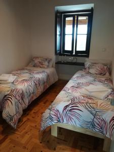 two beds sitting next to each other in a room at Quinta dos Capuchos Casa da Adega in Alcobaça