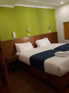 
a hotel room with two beds and two lamps at Martim Moniz 28 Guest House in Lisbon
