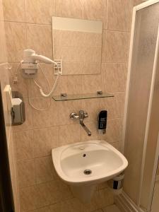 Ubytovanie Violet في Važec: حمام مع حوض وهاتف على الحائط