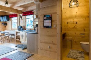 kuchnia i salon w drewnianym domku w obiekcie TatryTop Osada Luxury Chalets Kościelisko w mieście Kościelisko