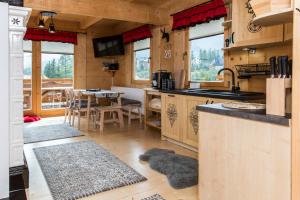 kuchnia z blatem i jadalnia ze stołem w obiekcie TatryTop Osada Luxury Chalets Kościelisko w mieście Kościelisko