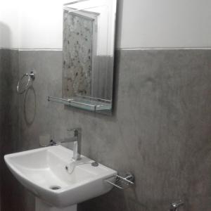 baño con lavabo y espejo en la pared en calm house dickwella, en Dikwella