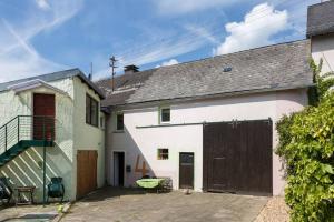 a cottage with a garage and a house with a roof at Grünes Appartment Nürburgring in Drees