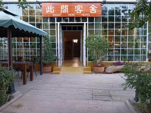 einen Eingang zu einem Gebäude mit einem Schild darauf in der Unterkunft Right Here Hotel (Dunhuang International Youth Hostel) in Dunhuang