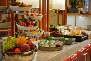 a buffet with fruits and other food on a table at Hotel Metropol by Maier Privathotels in Munich