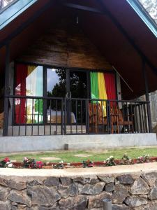 a house with a balcony with a rainbow flag at Fair View Cottage in Ella