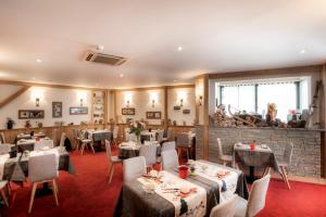 a restaurant with tables and chairs in a room at Hotel Le Littoral in Évian-les-Bains