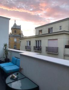 - un balcon avec un canapé bleu au-dessus d'un bâtiment dans l'établissement City Center Penthouse, à Budapest