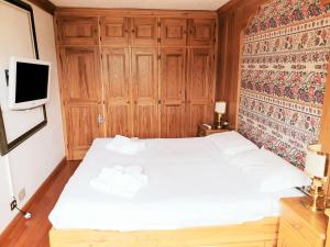 コルティーナ・ダンペッツォにあるSupermountainski Cortinaのベッドルーム(白いベッド1台、テレビ付)