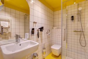 a bathroom with a sink and a shower and a toilet at MEININGER Hotel Bruxelles Gare du Midi in Brussels