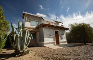 una casa blanca con un cactus delante en Casa Serendipia en Puerto Pirámides