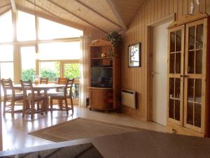 a dining room with a table and chairs and a television at Ferienhaus Strandmuschel in Schönhagen