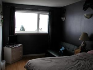 a bedroom with a bed and a window at Fireflies Bed & Breakfast in Campbell River