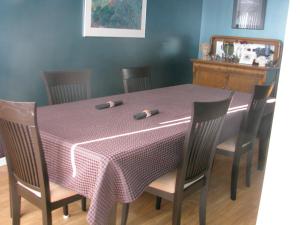 einen Esstisch mit einem Tischtuch und Stühlen in der Unterkunft Fireflies Bed & Breakfast in Campbell River