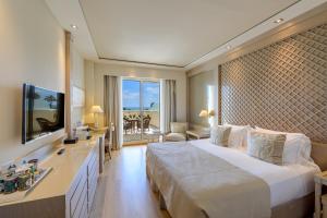 a hotel room with a large bed and a television at Las Arenas Balneario Resort in Valencia