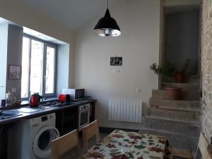a kitchen with a washing machine and a table at Galerie Benjamine in Vézelay