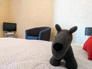 a stuffed animal is sitting on a bed at Studio calme et confortable proche de Saint-Chamond in LʼHorme