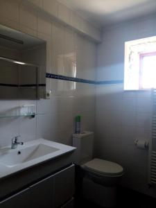 セロリコ・デ・バストにあるCasas do Eido e Casa da Viúvaのバスルーム(トイレ、洗面台付)、窓が備わります。
