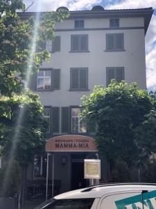 un edificio blanco con un cartel delante en Haus zur Eiche Private 3,5 Zimmerwohnung bis zu 8 Gäste, en Chur