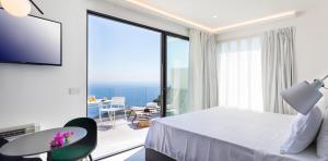 a hotel room with a bed and a large window at The View Luxury Apartments Taormina in Taormina