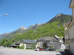 una città in montagna con auto parcheggiate in un parcheggio di Appartement Cauterets a Cauterets